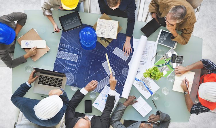 Architects & Builders sitting around a table looking at blueprints