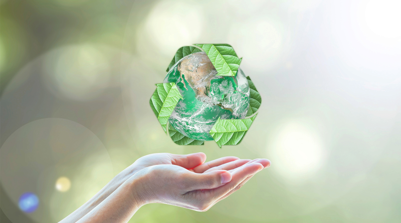 person holding a recycle symbol made out of trash to support waste management article